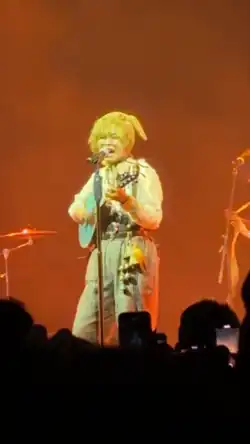 Yaelokre performing on a concert stage with a guitalele