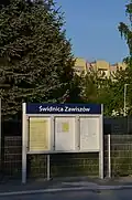 Tablica z rozkładem jazdy, w tle zabudowania Osiedla Zawiszów
