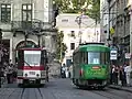 Tramwaje linii 1 oraz linii 9 podczas postoju na przystanku. Rynek we Lwowie. Widok na ulicę Ruską w kierunku Cerkwi Wołoskiej i Domu Proświty