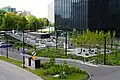 Skwer przy biurowcach, widziany z kładki nad ulicą Olimpijską (2024)
