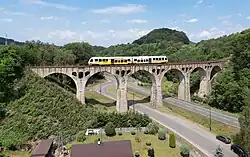 Widok ogólny na wiadukt z przejeżdżającym przez niego szynobusem