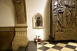 Widok na fragment tablicy-epitafium Cypriana Kamila Norwida i urnę z ziemią z jego grobu