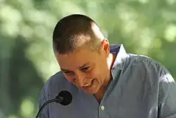 Kobieta w wieku czterdziestu lat uśmiecha się na mównicy