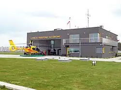 Śmigłowiec wyjeżdża z hangaru na platformie transportowej