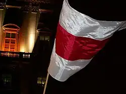 Demonstranci używający narodowej symboliki Białorusi na wiecu