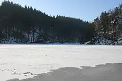 Kładka przewieszona nad zamarzniętym Jeziorem Modrym w okolicy schroniska Perła Zachodu