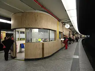 Kiosk dyżurnego peronowego na modernistycznym dworcu centralnym w Brukseli (1952). Kiosk jest wyposażony w okna ze szkłem giętym i ozdobiony trawertynem