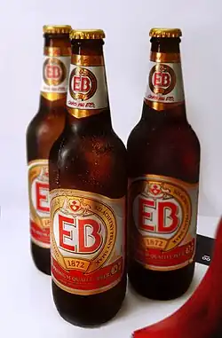 zdjęcie przedstawia trzy brązowe butelki piwa z białą etykietą i czerwonymi literami EB