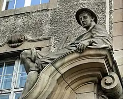 Rzeźba mężczyzny nad wejściem do gmachu od al. Niepodległości