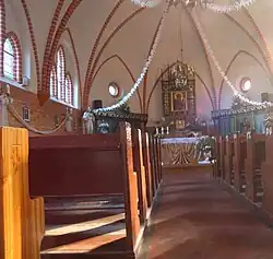 Wnętrze z ołtarzem i ławami kolatorskimi