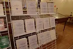 Na metalowym regale ustawiono 14 tomów tureckiego wydania słownika E. Piekarskiego.