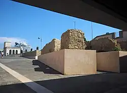 Widok portu w Neapolu z wyjścia stacji Municipio, z panoramą pozostałości murów starożytnego portu.