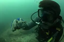 Piotr Wytykowski trzyma porcelanową filiżankę odnalezioną podczas eksploracji wraku Diemermeer