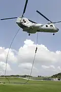 Amerykański żołnierz Piechoty Morskiej opuszcza śmigłowiec CH-46E Sea Knight stosując technikę fast rope