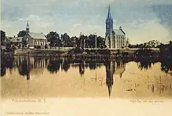 Staw w Parku Hutniczym (Hüttenpark) z widocznymi kościołami – ewangelickim i katolickim – na drugim planie (pocztówka z przełomu XIX i XX w.)