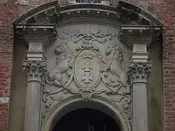 Herb nad wejściem do Ratusza Głównego Miasta ma nietypowe lwy: jeden z nich jest odwrócony, jakby wyczekiwał pomocy.