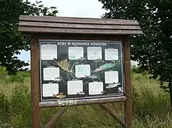 Tablica informacyjna dotycząca występujących w stawie ryb