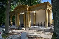 Klasycystyczny grobowiec Riedingerów zwieńczony tympanonem z motywem promienistego słońca oraz napisem Familie Riedinger.