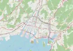 Mapa konturowa Hiroszimy, blisko górnej krawiędzi po lewej znajduje się punkt z opisem „Stadion Hiroshima Big Arch”