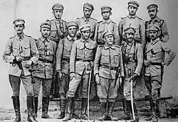 Polski: II pluton Pierwszej Kompanii Kadrowej w Krakowie. 1. rząd, 1. od lewej: Modest Słoniowski ps. „Słoń”. Kolejni na tym zdjęciu: sierż. Kazimierz Strzelecki ps. „Kazik” (lub sierż. Zygmunt Pomarański ps. „Brzózka”), ppor. Mieczysław Marusieński ps. „Lelum”, sierż. Kazimierz Kamiński ps. „Luboń” (lub Sław Płoszajski ps. „Sławomir”), Wacław Sieroszewski, Krok-Paszkowski, Zygmunt Platonoff ps. „Plater”. 2 rząd, od lewej: por. Bronisław Mansperl ps. „Haber”, Stefan Pomarański ps. „Borowicz”, Roman Szymański ps. „Tewański”, Wiktor Bystrzyński ps. „Skrzetuski”, Eugeniusz Czajkowski ps. „Jarzębie Marian”.