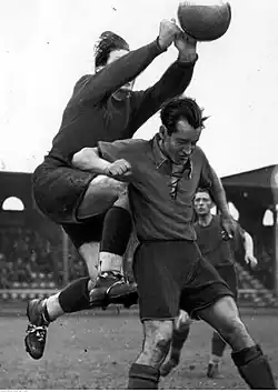 Piłkarz DTSG Krakau Józef Smoczek w walce o piłkę z bramkarzem drużyny piłkarskiej Luftwaffe (1941).