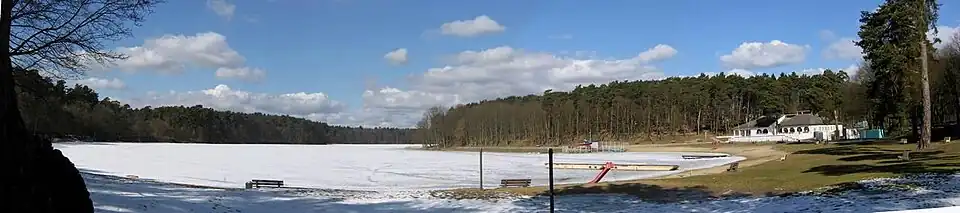 Widok na Jezioro Głębokie zimą, w tle Park Leśny Głębokie