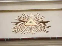 Oko opatrzności wieńczące attykę  na fasadzie kamienicy Hipolitów w Krakowie