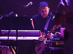 Kamil Pater grający na gitarze za konsolą.