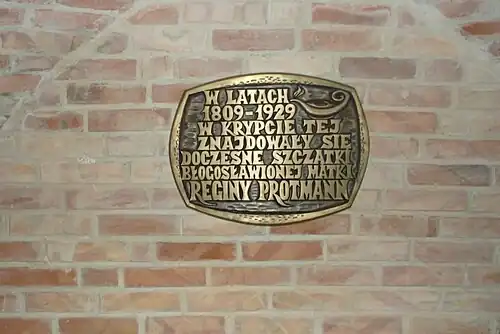 Tablica informująca o miejscu spoczynku w niej bł. Reginy