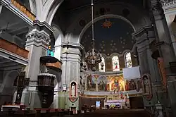 Kościół Zesłania Ducha Świętego w Łodzi ul. Piotrkowska 2/2a. W głębi, jakościowo dobrze widoczna polichromia na ścianie i na stropie prezbiterium: na ścianie malowidło Zesłanie Ducha Świętego, girlandy pod gzymsem, ornamenty na stropie i na łukach, fragmenty domalowanych witraży.