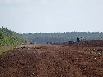 Maszyny pracujące przy wydobyciu torfu w kopalni Karaska