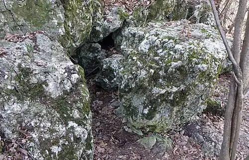 Głaz, za którym jest otwór korytarzyka