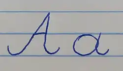 Odręczny zapis litery „a” (majuskuły i minuskuły).
