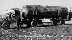 Czarno-białe zdjęcie ciężarówki z kłodą daglezji zielonej