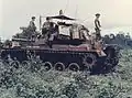 M48A5 Patton w Wietnamie. Uwagę zwraca ilość sprzętu przewożona przez załogę na pancerzu czołgu (których dodatkowym zadaniem była ochrona pancerza właściwego przed pociskami RPG), oraz prowizoryczna ochrona przed słońcem nad włazami wieży.