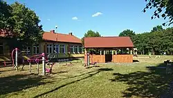 Wiata, siłownia zewnętrzna i plac zabaw, po lewej świetlica wiejska
