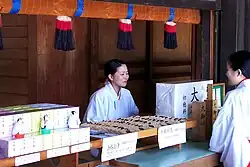 Miko w stoisku sprzedaży wróżb i pamiątek