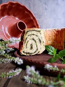 Potica w wersji z nadzieniem miętowym, z tyłu po lewej widoczny potičnik