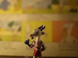 Figurka Koziołka Matołka na tle komiksu