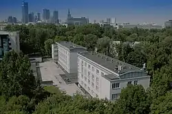 Warszawa z lotu ptaka. Na pierwszy planie dwa budynki 4 piętrowe. W tle widać wieżowce w centrum stolicy