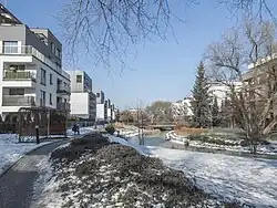 Podłużny staw położony na terenie osiedla zimą