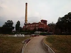 Plac z fontanną, w tle stara gazownia miejska