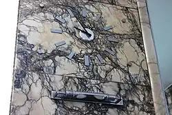 Zegar na marmurowej okładzinie ściany