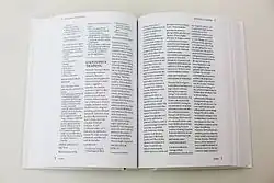 Zdjęcie przedstawia tom encyklopedii na białym stole, otwarty, ujęty pionowo z góry. Na zadrukowanych tekstem stronach widoczne m.in. hasło opisane w podpisie zdjęcia.