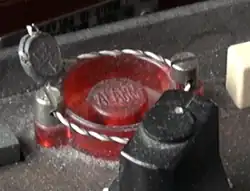 Czerwony przycisk z plombą i napisem "Alarm"