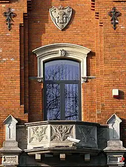 Detale ryzalitu gmachu dawnej Kasy Przemysłowców Radomskich. Nad portalem widoczny herb Guberni radomskiej.