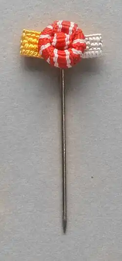 Rozetka Krzyża Komandorskiego z Gwiazdą Orderu Odrodzenia Polski (ze złoto-srebrnym galonikiem).