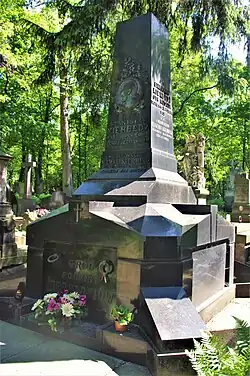 Duży grób na tle zielonych drzew. Jest to grobowiec rodzinny rodziny Kierbedziów. Grób ma kształt graniastosłupa z mosiężnymi literami i okrągłym portretem Stanisława Kierbedzia. Na dole grób jest szerszy, o prostych geometrycznych kształtach