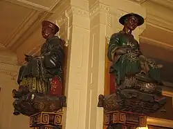 Statuetki Magots (akwizytorów) na jednym z filarów kawiarni Les Deux Magots