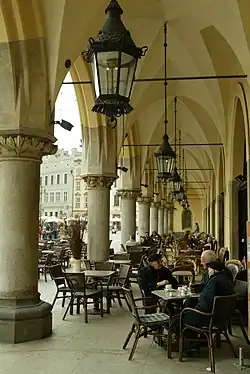 Goście przy stolikach przed kawiarnią